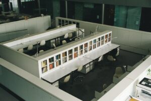 Rows of study desks and glass-fronted bookshelves in an open-plan university library